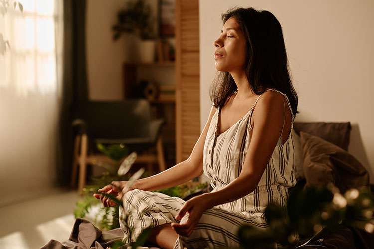 A woman meditating while manifesting her dream life.