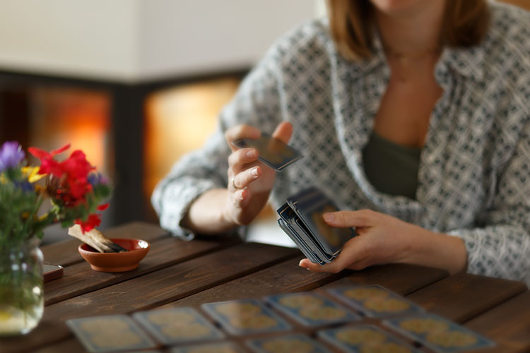 A psychic shuffling a deck of tarot cards before performing tarot card readings for a client.