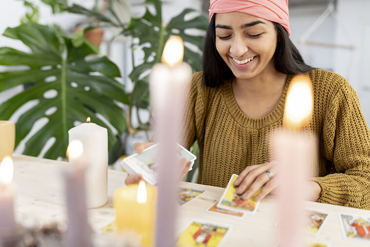 Modern-day fortune teller using tarot cards and candles.